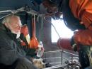An elderly sailor and his dog were rescued off the coast of Ensenada, Mexico after a ham in Texas heard his distress call on 14.300 MHz. In this USCG photo, he is pictured safely aboard Coast Guard helicopter with USCG Petty Officer 2nd Class James Johnson. [USCG Petty Officer 2nd Class Henry G. Dunphy, Photo]