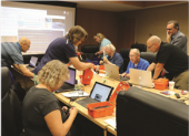 Many teachers working on an activity at the table during a Teachers Institute session at ARRL headquarters.